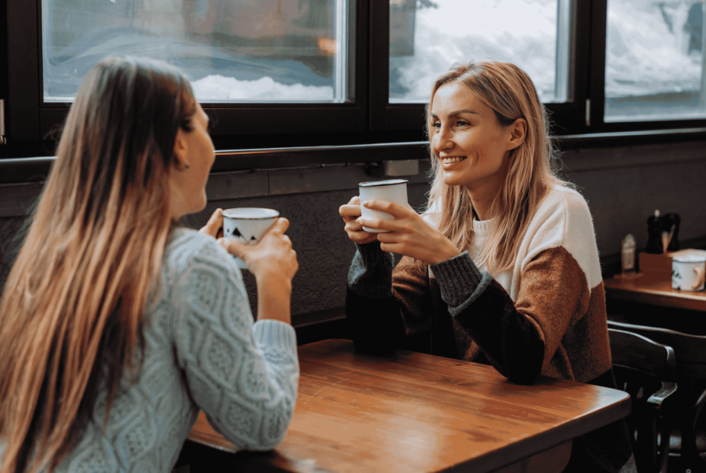 two women in perimenopause enjoying a cup of coffee together