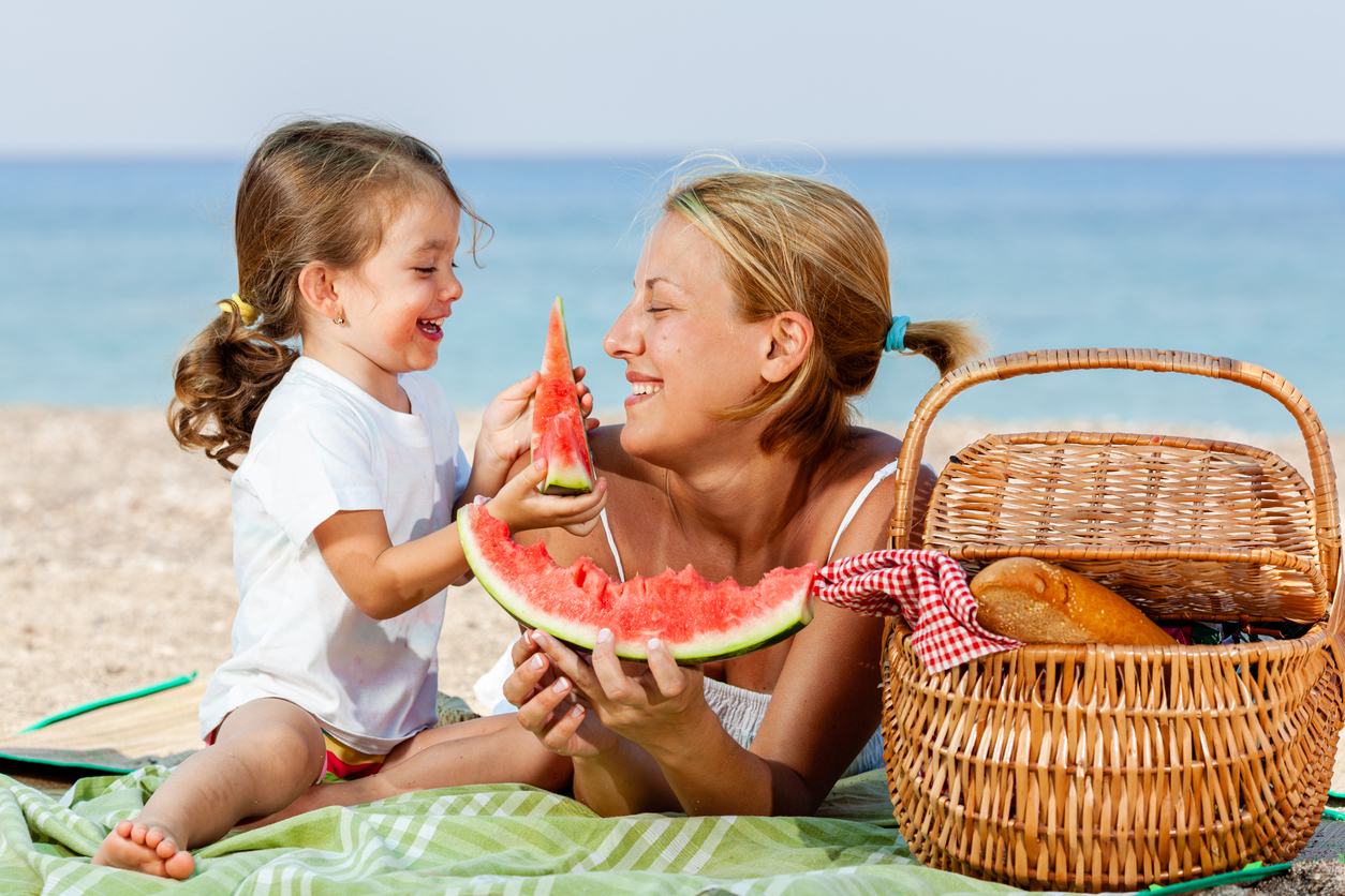 Mother and daughter having a picnic at the beach