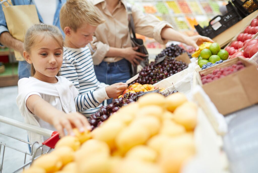 close up of a family and kids picking out fresh produce after consulting with a calgary dietitian