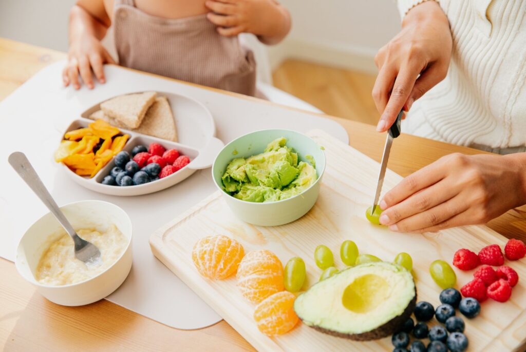 mom cutting up foods for introducing solids to baby