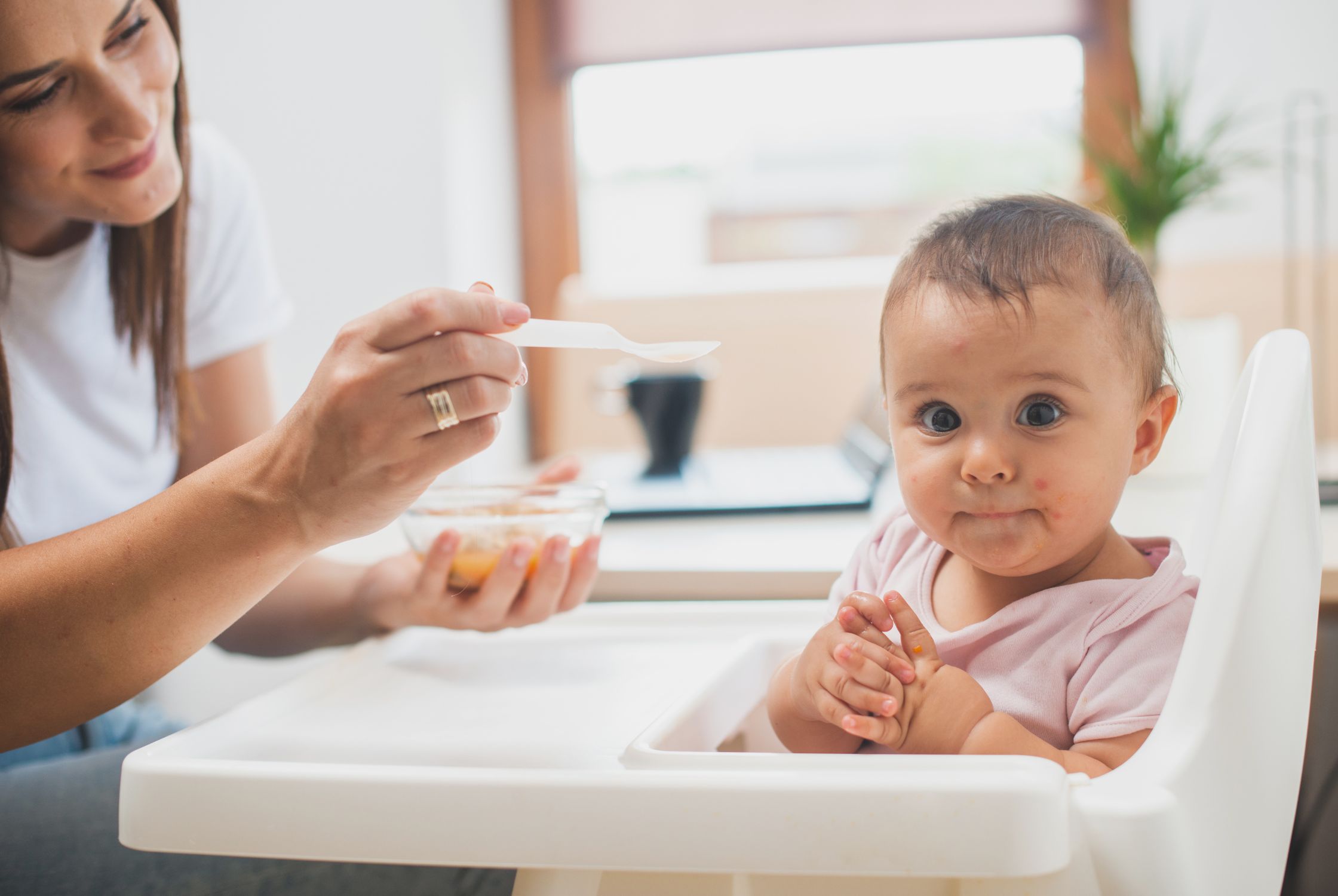 close up of mom introducing allergens to baby