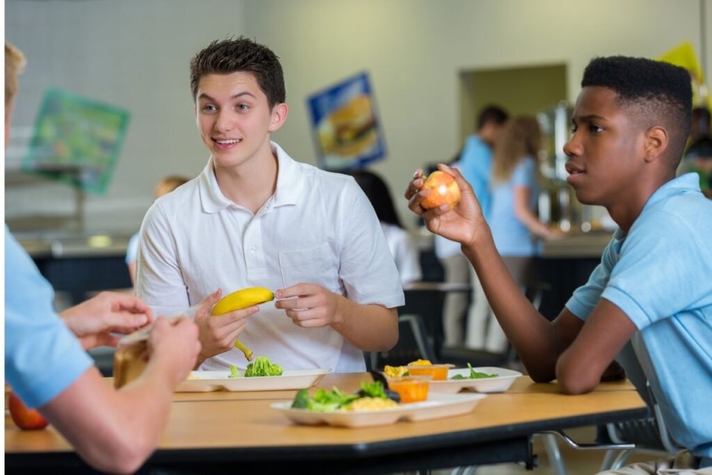 a group of teens eating lunch together at school