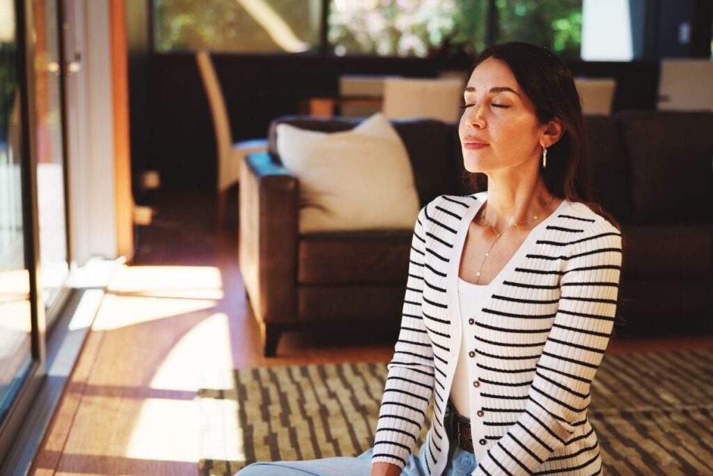 a woman using breath work to manager her stress levels