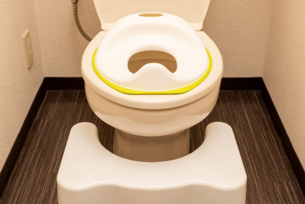 close up of a squatty potty next to a toilet for kids