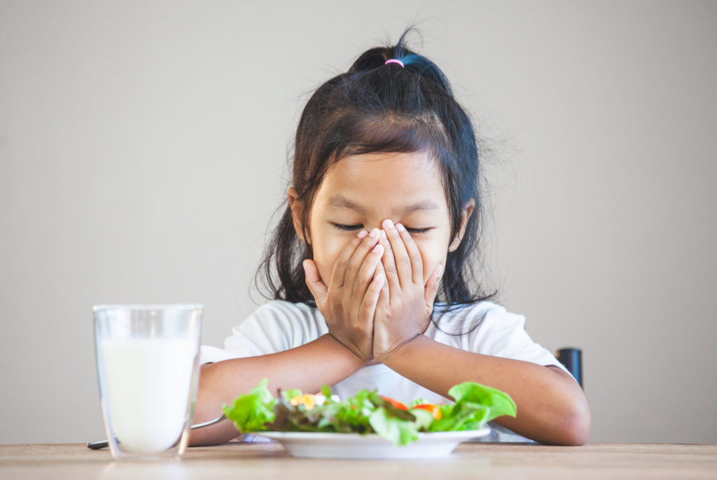 a girl struggling with sensory challenges at mealtime and overwhelmed by her eating environment