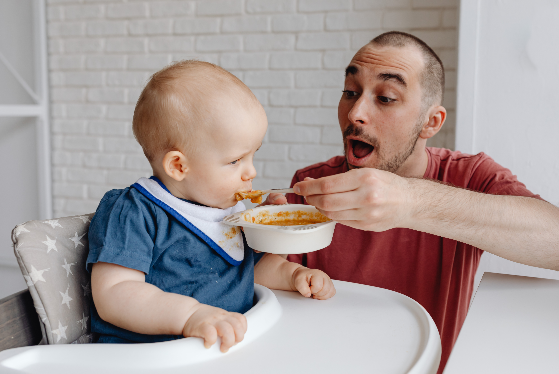 a father feeding his baby girl in hope to prevent picky eating